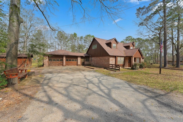 view of property exterior featuring driveway, an attached garage, brick siding, a yard, and board and batten siding