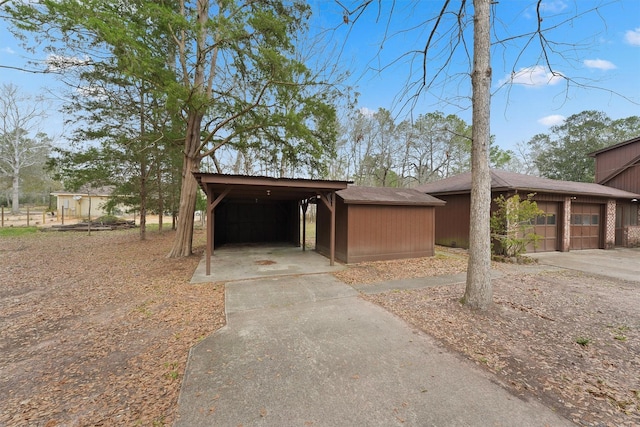 view of front of property featuring an outbuilding, a carport, and concrete driveway