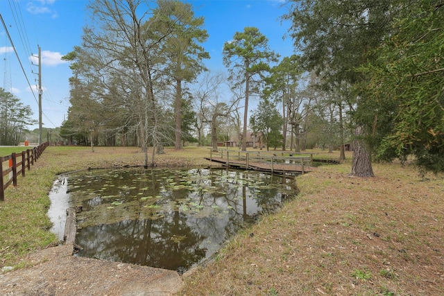 exterior space with a water view and fence