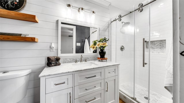 bathroom featuring toilet, a stall shower, and vanity