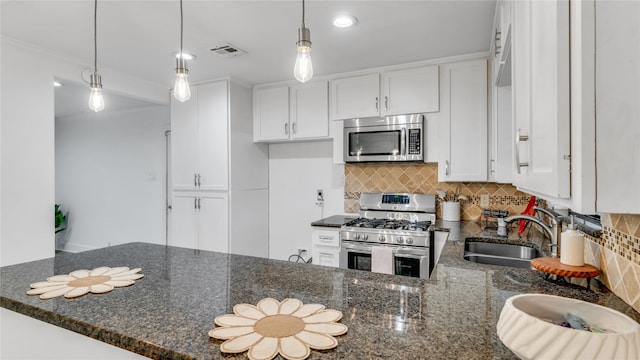 kitchen with a sink, visible vents, white cabinets, appliances with stainless steel finishes, and dark stone counters