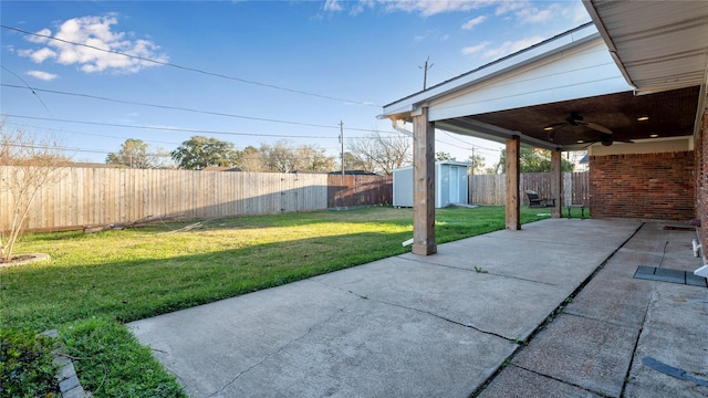 view of patio featuring a fenced backyard, a storage unit, a ceiling fan, and an outbuilding