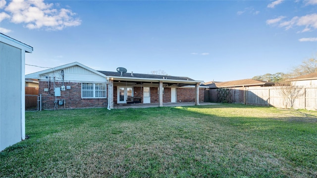 back of property with a yard, a fenced backyard, a patio, and brick siding