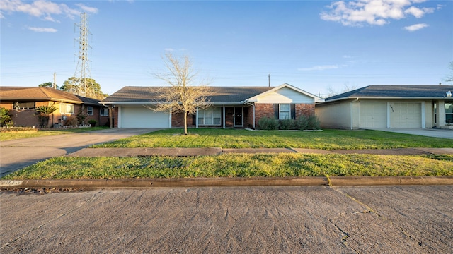 ranch-style home featuring concrete driveway, brick siding, an attached garage, and a front yard