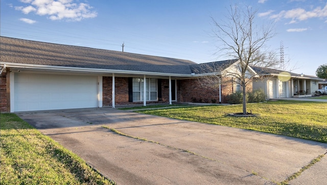 single story home featuring driveway, a garage, a shingled roof, a front lawn, and brick siding