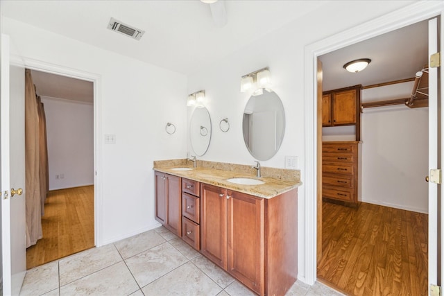 bathroom with double vanity, visible vents, tile patterned floors, and a sink