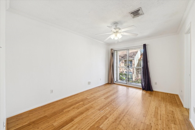 unfurnished room featuring a textured ceiling, crown molding, visible vents, and light wood-type flooring