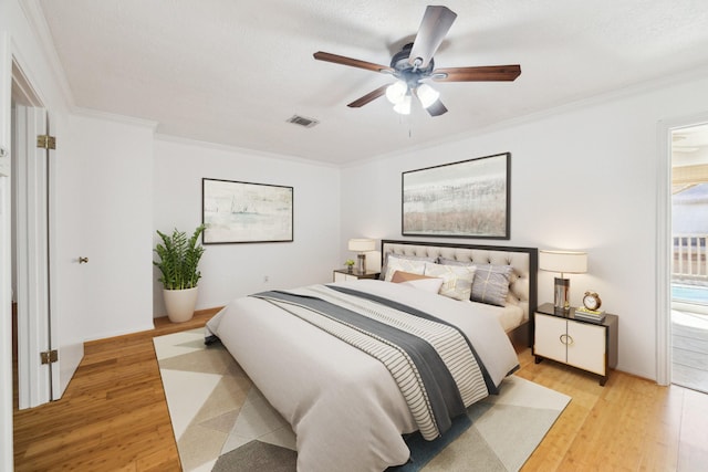 bedroom with visible vents, a ceiling fan, crown molding, and light wood finished floors