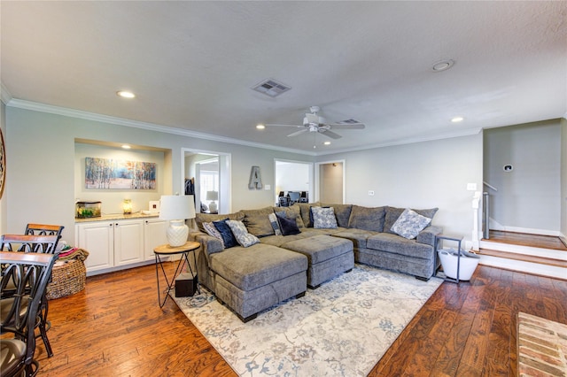 living area with dark wood-style flooring, visible vents, and crown molding