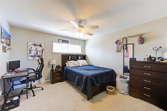 bedroom with ceiling fan, baseboards, and light colored carpet