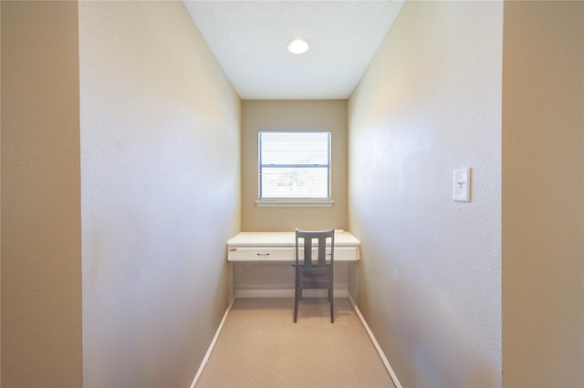 interior space featuring light carpet and baseboards