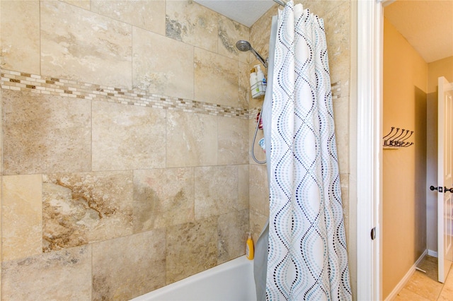 bathroom featuring shower / bath combination with curtain and baseboards