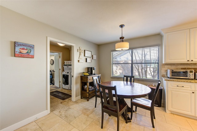 dining space featuring light tile patterned floors, a toaster, and baseboards