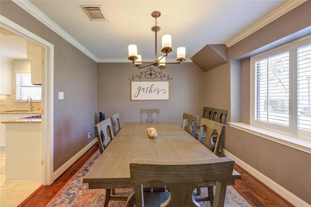 dining room featuring dark wood-style floors, visible vents, and crown molding