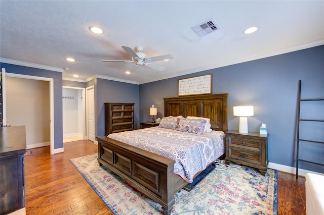 bedroom featuring baseboards, visible vents, wood finished floors, crown molding, and recessed lighting