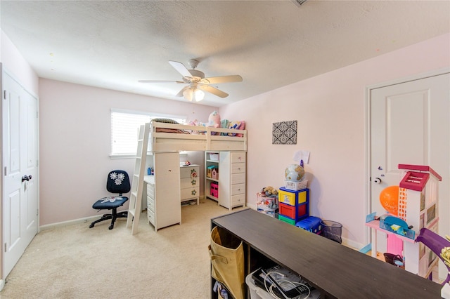 bedroom featuring ceiling fan, a textured ceiling, baseboards, and light colored carpet