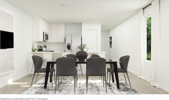 kitchen with light wood-type flooring, white appliances, white cabinets, and baseboards