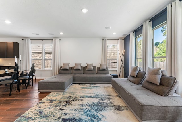 living area featuring baseboards, dark wood-type flooring, visible vents, and recessed lighting