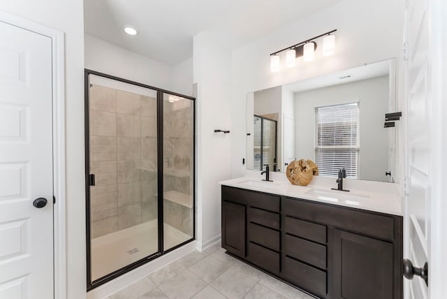 full bathroom with a stall shower, tile patterned flooring, a sink, and double vanity