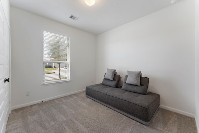 living area featuring carpet, visible vents, and baseboards