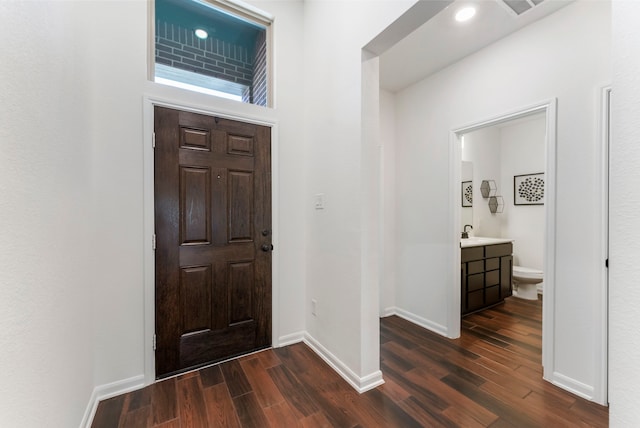 entrance foyer with dark wood-style floors and baseboards