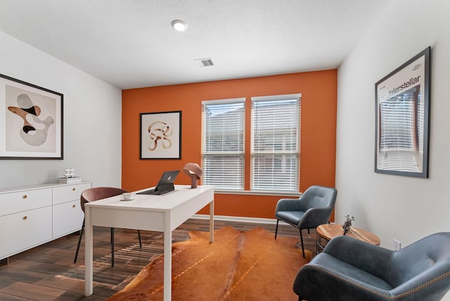 office featuring dark wood-type flooring, visible vents, and baseboards