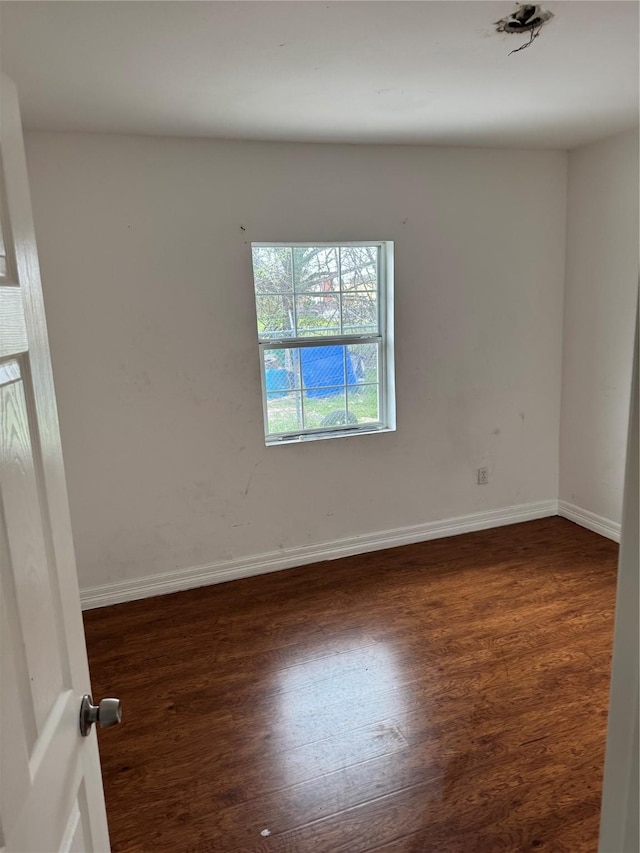 unfurnished room with baseboards and wood finished floors