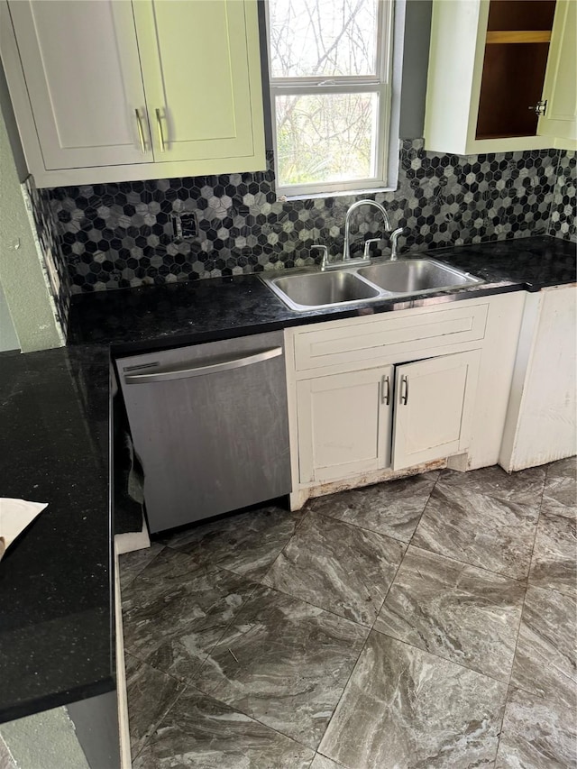 kitchen with dishwasher, backsplash, dark countertops, and a sink