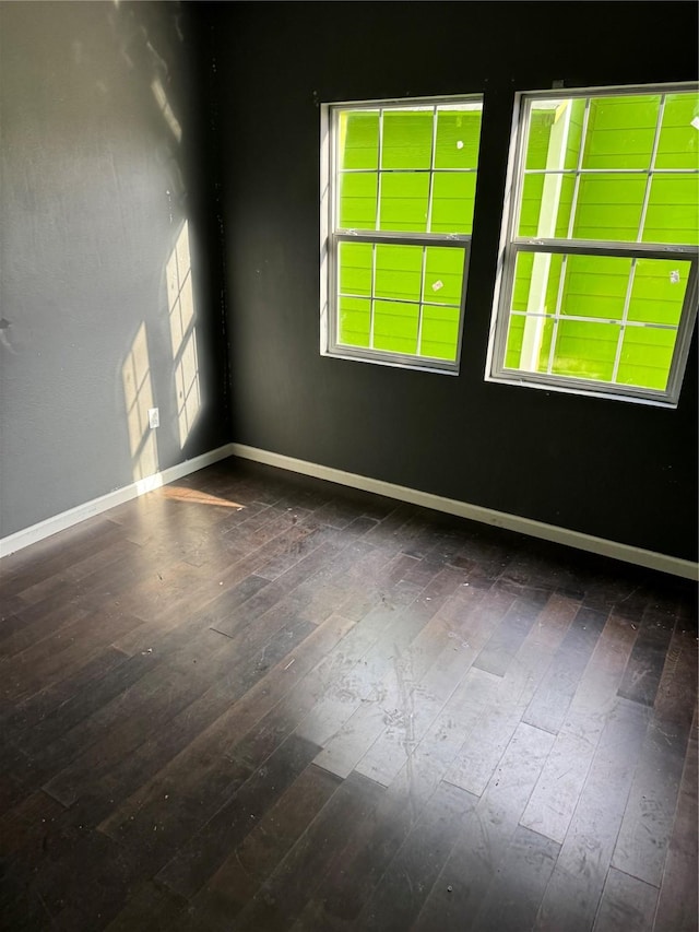 unfurnished room with wood-type flooring and baseboards