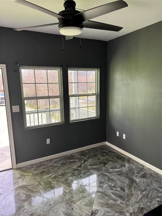 unfurnished room featuring marble finish floor and baseboards