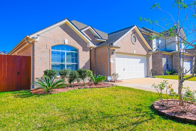 view of front of home with brick siding, a shingled roof, an attached garage, driveway, and a front lawn