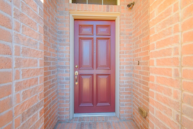 entrance to property featuring brick siding