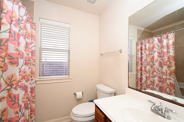 bathroom featuring curtained shower, toilet, visible vents, vanity, and baseboards