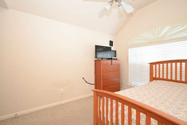 carpeted bedroom featuring baseboards, vaulted ceiling, and a ceiling fan