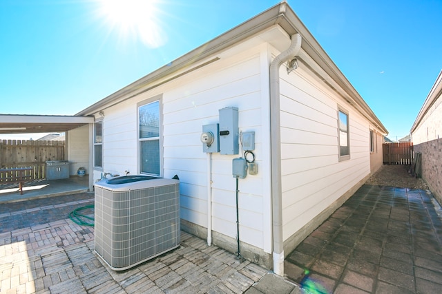 view of side of home with a fenced backyard, a patio area, and cooling unit