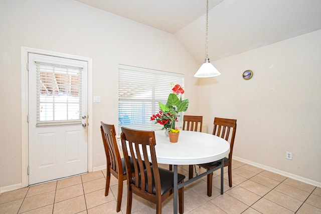 dining room with lofted ceiling, baseboards, and light tile patterned flooring