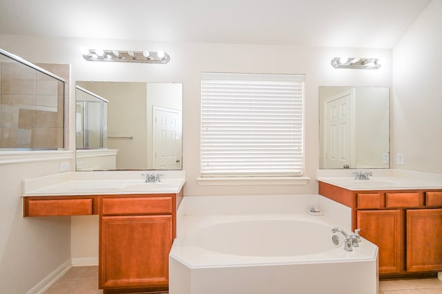 bathroom with a garden tub, two vanities, a sink, a shower stall, and tile patterned floors