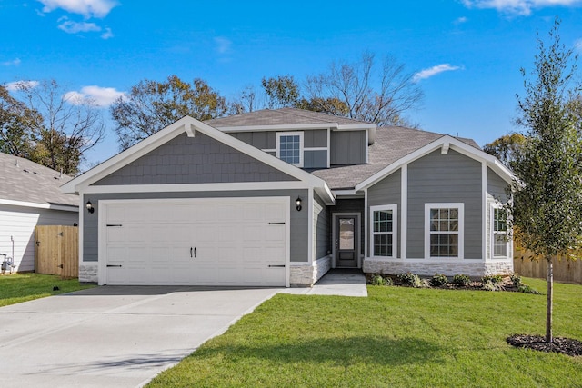 view of front of home with an attached garage, stone siding, fence, and a front yard