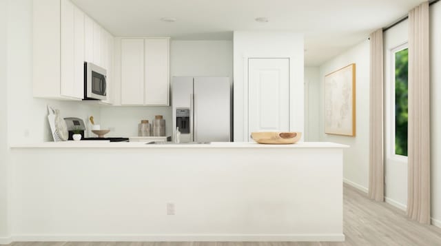 kitchen featuring light countertops, fridge with ice dispenser, stove, and white cabinetry