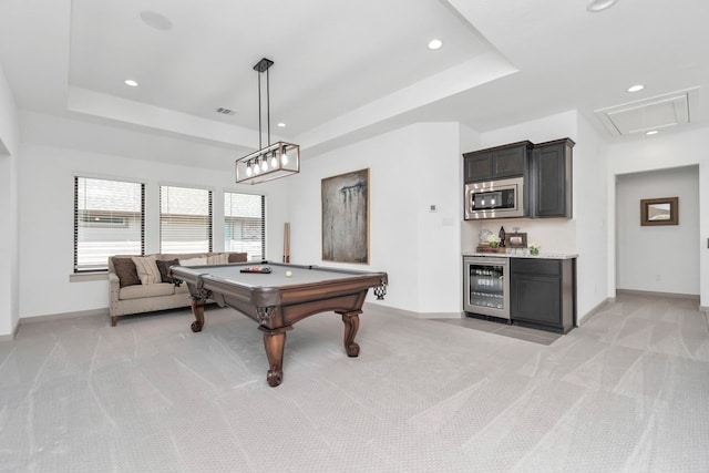 rec room with wine cooler, a raised ceiling, and light colored carpet