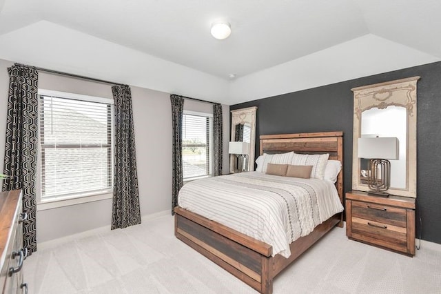 bedroom with lofted ceiling, baseboards, and light colored carpet