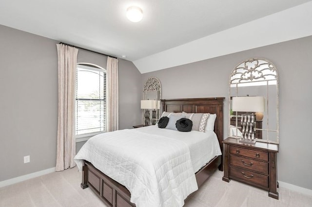 bedroom featuring light carpet, vaulted ceiling, and baseboards