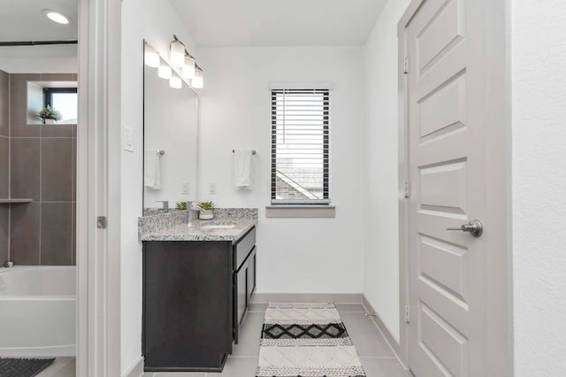 full bathroom with baseboards, vanity, a bath, and tile patterned floors