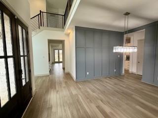 interior space with light wood-type flooring and a high ceiling