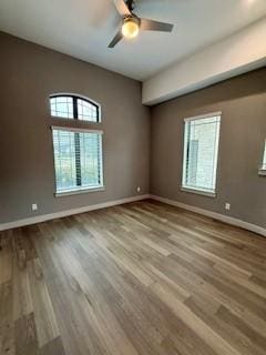 spare room with ceiling fan, baseboards, and wood finished floors