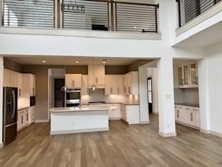 kitchen with dark wood finished floors, a towering ceiling, and freestanding refrigerator