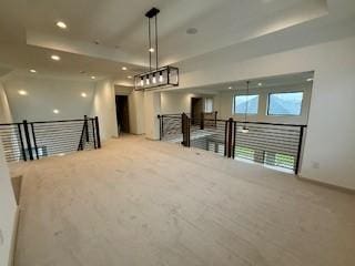 interior space with carpet, baseboards, a raised ceiling, and recessed lighting