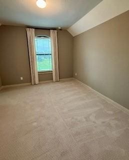 additional living space featuring light carpet, baseboards, and vaulted ceiling