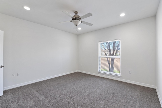 empty room with dark colored carpet, recessed lighting, and baseboards