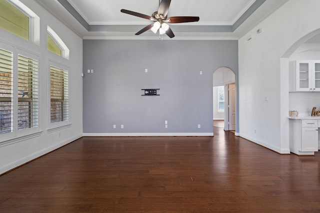 unfurnished living room with ceiling fan, arched walkways, dark wood-style flooring, and crown molding